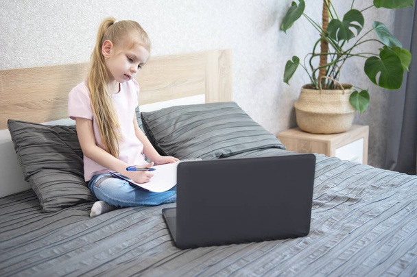 Schoolgirl studying at home using laptop. Stay at home. Online education, home education, quarantine concept. - Photo, Image