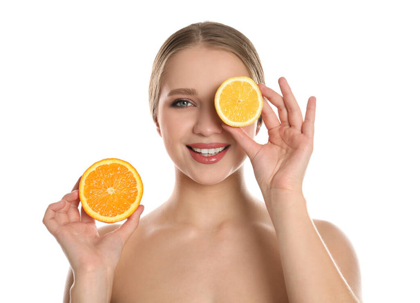Beyaz arka planda kesik turuncu ve limonlu genç bir kadın. Vitamin zengini yiyecekler - Fotoğraf, Görsel