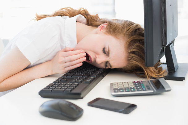 Businesswoman resting head on keyboard at office - Photo, image