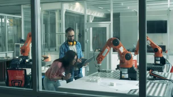 De jeunes chercheurs examinent des machines robotiques en mouvement
 - Séquence, vidéo