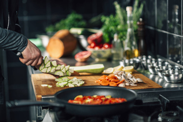 Cutting fresh zucchini. Chef making healthy vegan meal in restaurant, close-up - Φωτογραφία, εικόνα