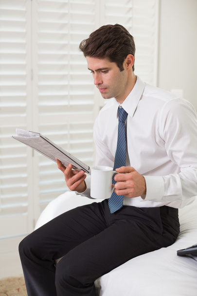 Businessman with coffee cup and newspaper at a hotel room - Photo, Image