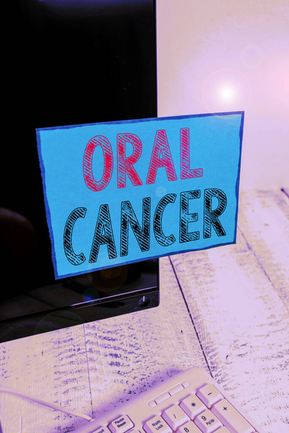 Написання тексту "Оральний рак". Бізнес-концепція раку підкладки губ рот або верхня горло Папір для позначення, прикріплений до екрану чорного комп'ютера біля білої клавіатури
. - Фото, зображення
