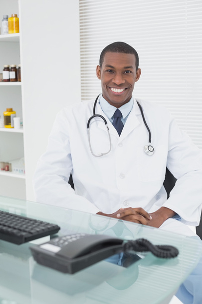 Smiling doctor with arms crossed in a medical office - Photo, image