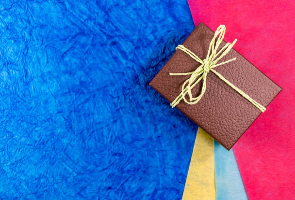 Szekrény egy barna ajándék doboz színes papírok a háttérben másolás helyet. Anyák napi ajándék koncept - Fotó, kép
