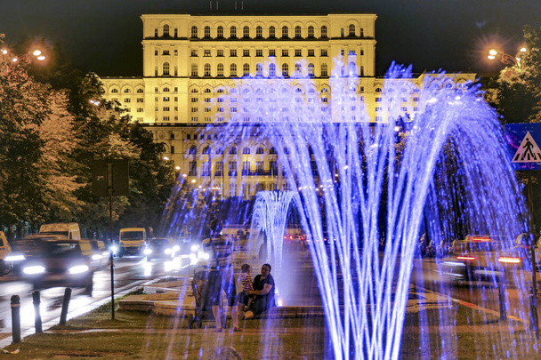 BUCHAREST, RUMUNSKO Boulevard Unirii, barevné fontány a palác parlamentu. - Fotografie, Obrázek