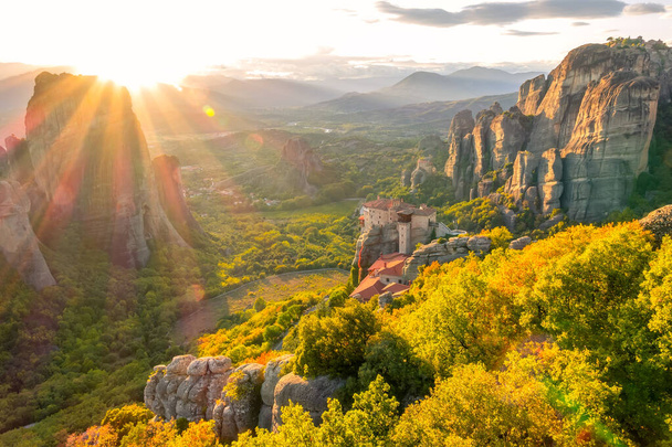 Greece. Summer sunset over valley of the rock monastery in Meteora (near Kalambaka) and sunbeams - Fotografie, Obrázek