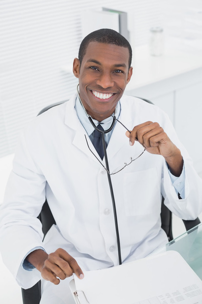 Smiling doctor with arms crossed in a medical office - Foto, afbeelding