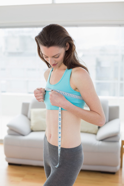 Toned woman measuring chest in fitness studio - Foto, Imagem