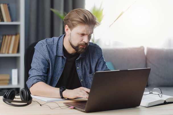 Felnőtt férfi dolgozik laptop, miközben otthon marad - Fotó, kép
