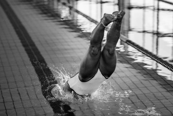 Жіночий плавець підстрибує в басейн
 - Фото, зображення