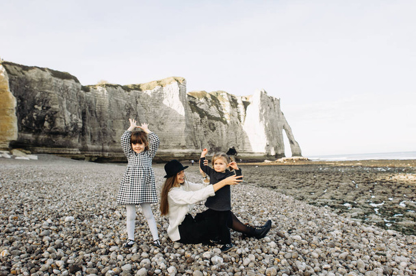 A beautiful young family on the sandy shore of the ocean relaxing and have a fun - 写真・画像