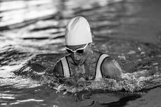 Kobieta pływaczka na treningu w basenie. Styl pływania na piersi - Zdjęcie, obraz