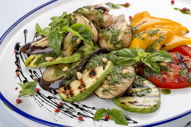 Grilled vegetables - tomatoes, zucchini, eggplant, sweet pepper, mushrooms. In a white plate - Foto, Imagen