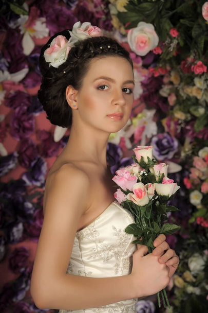 Young bride with flowers in her hair on a floral background - Fotografie, Obrázek