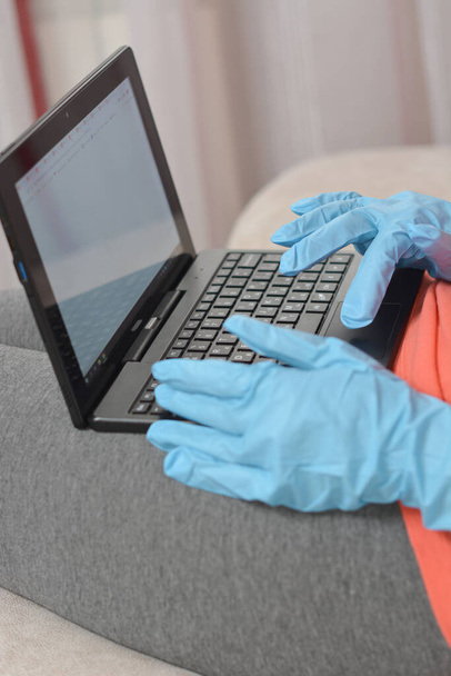 hand in blue rubber glove working at notebook - Zdjęcie, obraz