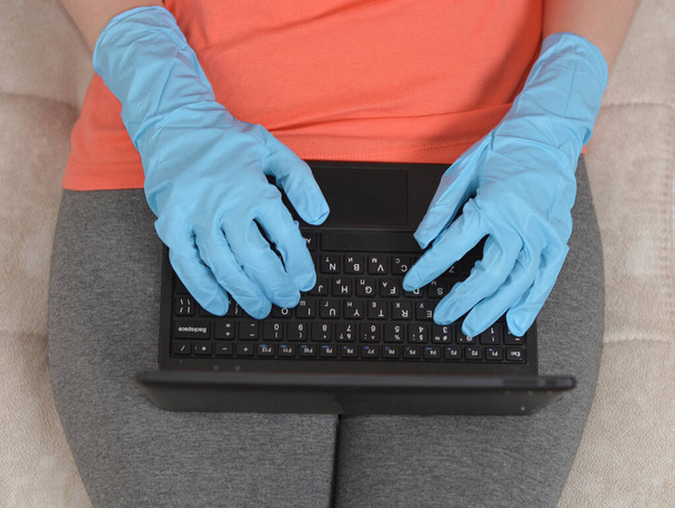 рука в синей резиновой перчатке, работающей в ноутбуке
 - Фото, изображение