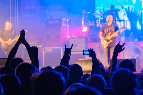 Fans hören Rockband auf der Bühne zu - Foto, Bild
