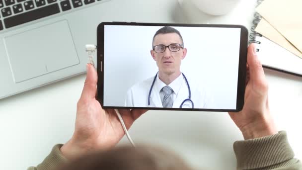 医師はタブレット画面上のオンラインチャットで助言します。患者と男性医師のリモート接続.ビデオ会議による医療支援. - 映像、動画