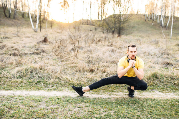 Attractive guy in headphones doing outdoor workout - Valokuva, kuva