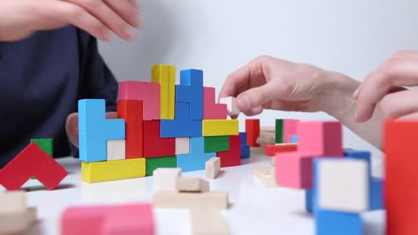 Руки человека, играющего в разноцветные игровые кубики. - Кадры, видео