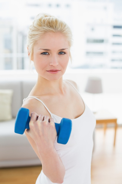 Thoughtful woman with dumbbells at fitness studio - Foto, immagini