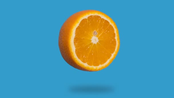 stop motion animation of fresh orange juice disappears, appears on a blue background - Filmati, video