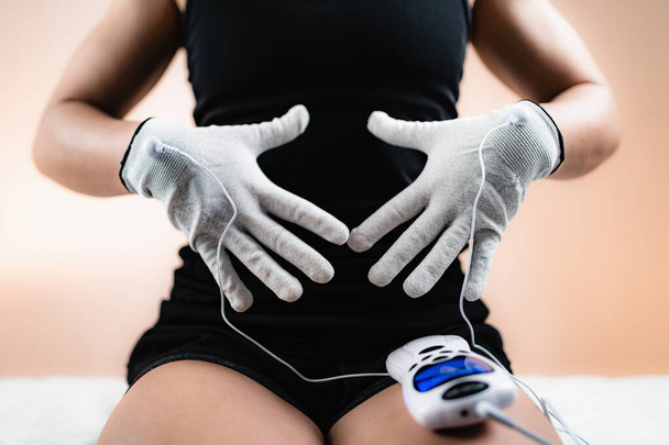 Physiothérapie manuelle avec gants conducteurs TENS Electricity, stimulation nerveuse électrique transcutanée
 - Photo, image
