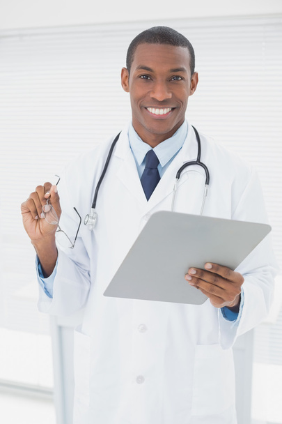 Smiling doctor writing a prescription in medical office - Foto, Imagen