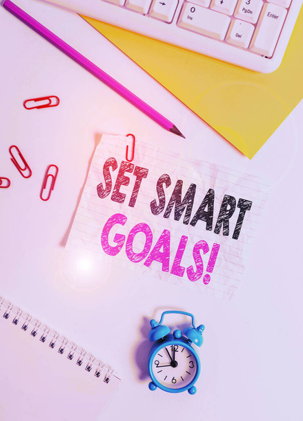 Text sign showing Set Smart Goals. Conceptual photo list to clarify your ideas focus efforts use time wisely Flat lay above white blank paper with copy space for text messages. - Photo, Image