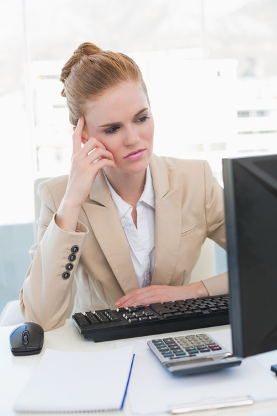 Worried businesswoman with computer at desk - Photo, Image