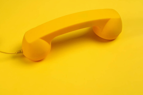 Sarı arka planda sarı bir cep telefonu. Boşluğu kopyala. - Fotoğraf, Görsel