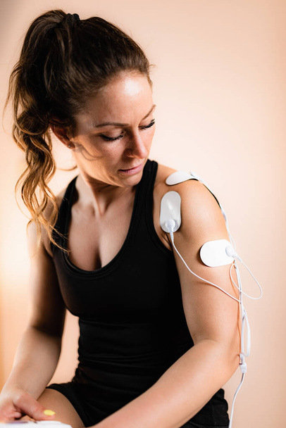 Плечова фізична терапія з електричними прокладками TENS, транскутантна електрична стимуляція запасу
.   - Фото, зображення