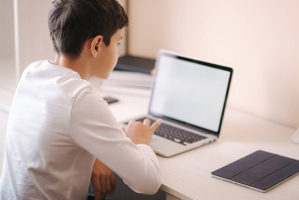 Schoolboy at home using laptop when studying. Teenage boy make homework on quarantine. Mockup - Foto, Imagem