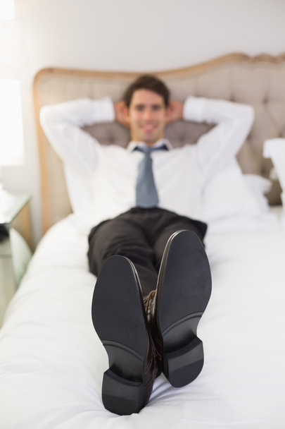 Rilassato sorridente uomo ben vestito sdraiato a letto
 - Foto, immagini