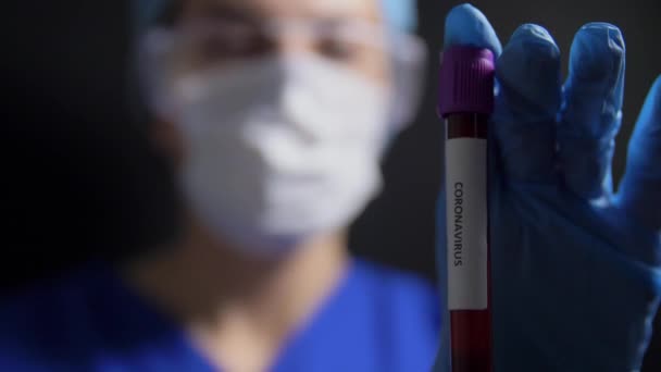 lekarz prowadzący zlewkę z badaniem krwi koronawirusa - Materiał filmowy, wideo