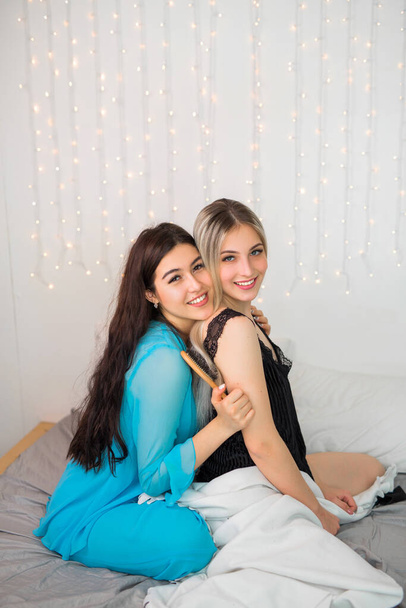 δύο όμορφες νεαρές γυναίκες στην κρεβατοκάμαρα στο κρεβάτι - Φωτογραφία, εικόνα
