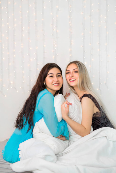two beautiful young women in the bedroom on the bed - Foto, imagen
