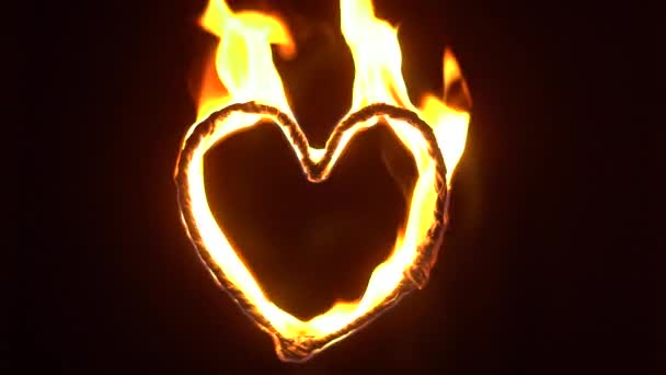炎の心。炎に輝くハート型。ビデオは夜遅くに撮影されました - 映像、動画