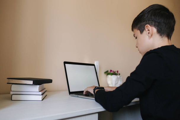 Evde paltipte genç bir çocuk. Genç çocuk evde online oyunlar oynuyor. Karantinada çalış. Qurantine sırasında mutlu okul çocuğu - Fotoğraf, Görsel