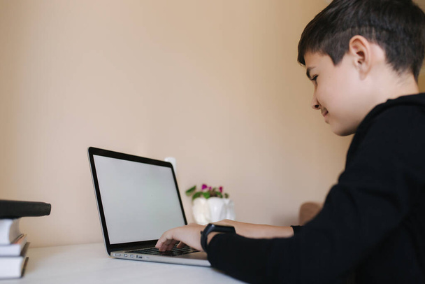 Teenagerjunge, der zu Hause an der Handfläche werkelt. Junge spielen Online-Spiele zu Hause. Studie in Quarantäne. Glücklicher Schuljunge während der Qurantine - Foto, Bild