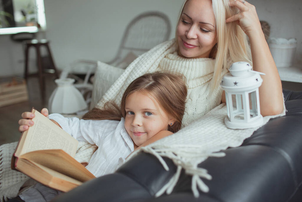 The family in the period of self-isolation reads books at home on the couch. How to keep yourself busy during quarantine without leaving your home - Photo, Image
