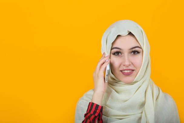  beautiful young woman in muslim shawl on yellow background - Foto, afbeelding