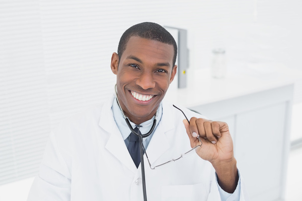 usmívající se doktor s náručí přešel v ordinaci - Fotografie, Obrázek