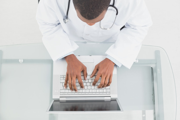 Overhead view of a male doctor using laptop - Foto, Bild