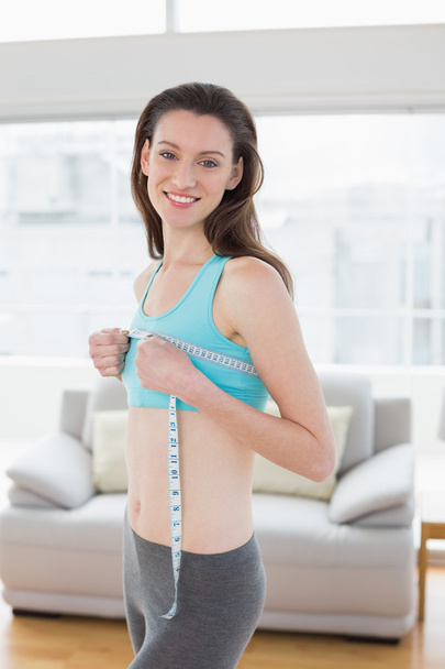Woman in sportswear measuring chest in fitness studio - Zdjęcie, obraz