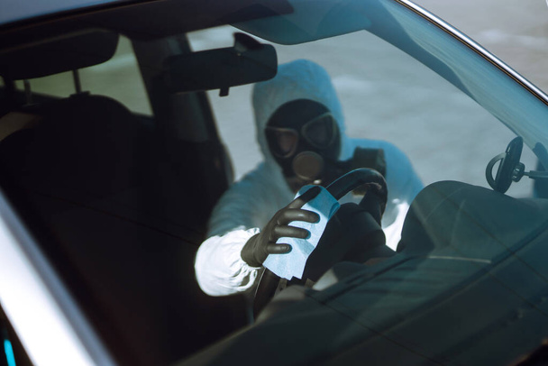 車の中でステアリングホイールの保護スーツ洗浄と消毒で人の手、 Covid-19ウイルスの感染、細菌や細菌の汚染を防ぐ. - 写真・画像