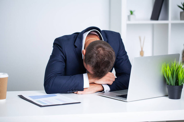 Tired employee working at desk at company office - Photo, Image