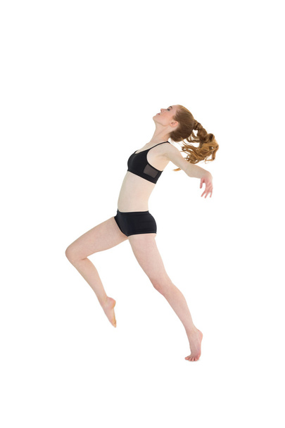 Full length of a sporty young woman jumping - Fotó, kép