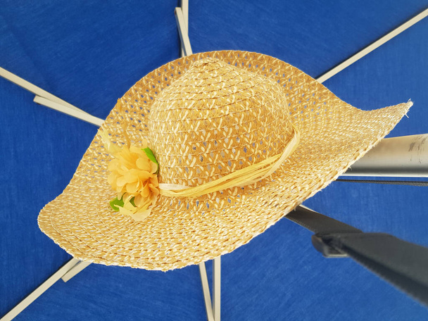 солом'яний капелюх з жовтою квіткою з парасольковим тлом
 - Фото, зображення